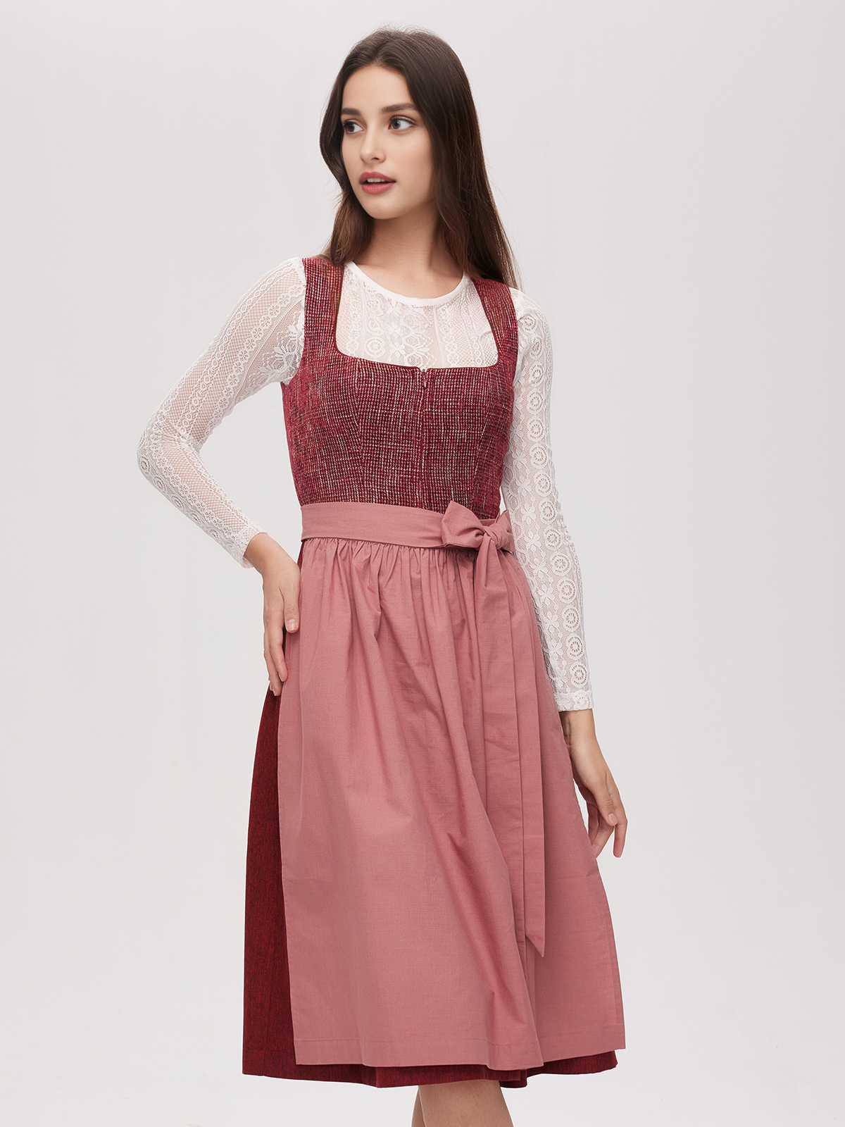 Ein rotes Dirndl mit traditioneller Schürze und passenden Accessoires
